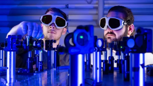 PhD students Paul Herrmann (left) and Sebastian Klimmer at a laser test setup.